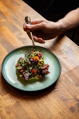 Tuna tartare with avocado on a green ceramic plate
