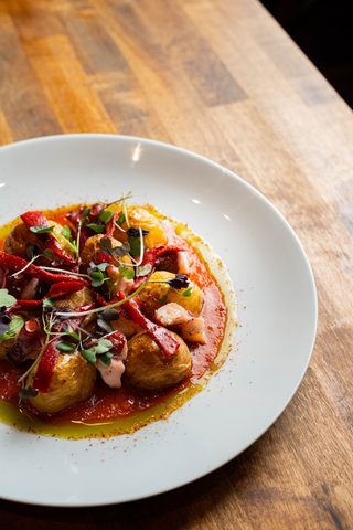 Grilled octopus with potatoes on a white plate