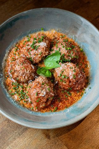 Meatballs in tomato sauce with grated cheese and basil
